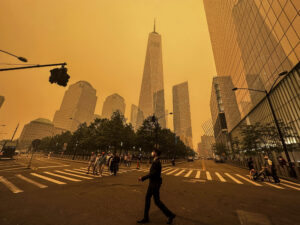 Pedestrians pass the One World Trade Center, center, amidst a smokey haze from wildfires in Canada, Wednesday, June 7, 2023, in New York. Smoke from Canadian wildfires poured into the U.S. East Coast and Midwest on Wednesday, covering the capitals of both nations in an unhealthy haze, holding up flights at major airports and prompting people to fish out pandemic-era face masks. (AP Photo/Julie Jacobson)